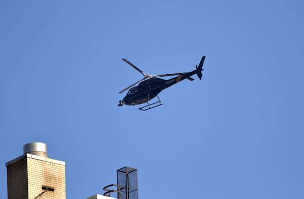 Camera helicopter flying low above buildings